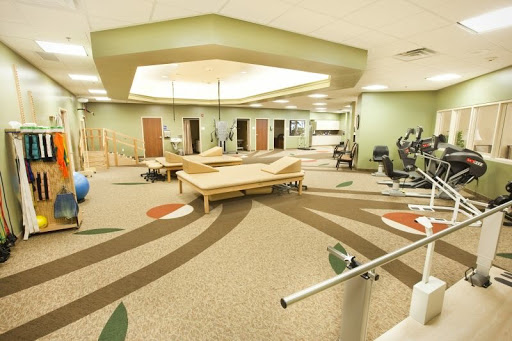 A spacious fitness and rehabilitation center, equipped with various exercise stations and a welcoming atmosphere.