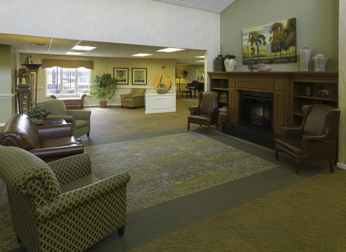 A spacious lobby area featuring comfortable seating, a fireplace, and decorative elements.