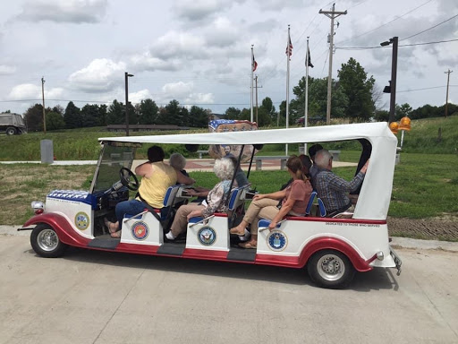 A group enjoying a ride in a colorful tourist cart on a sunny day.