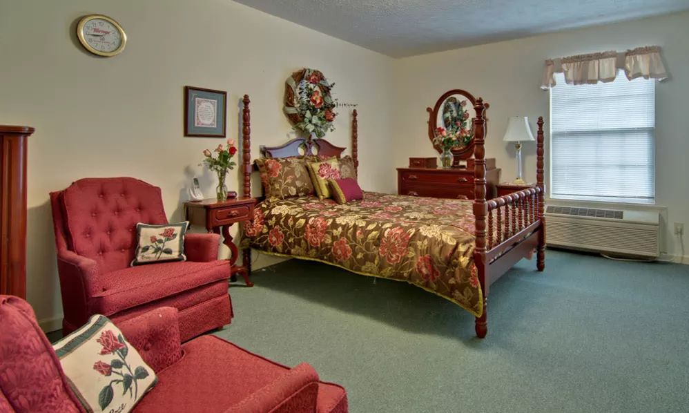 A traditionally decorated bedroom with a wooden bedframe and floral-themed bedding.
