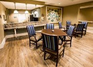 A cozy dining area with a modern design, featuring wooden floors and striped upholstered chairs.