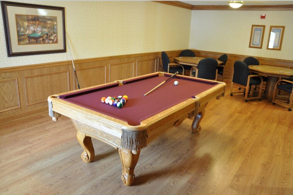 A cozy game room featuring a pool table with cues and balls ready for play.
