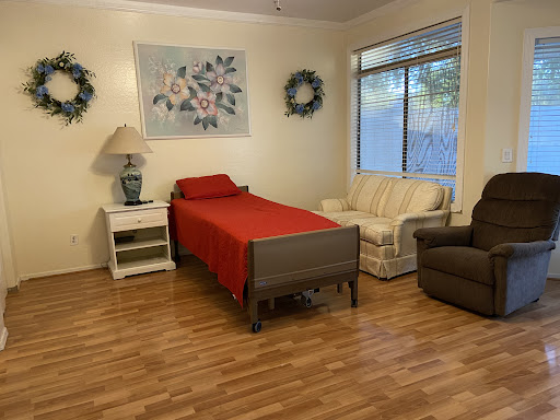 A cozy bedroom featuring a red bedspread, comfortable seating, and charming decorative elements.