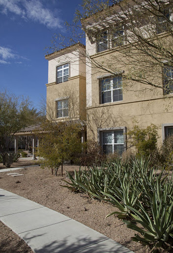 A modern residential building surrounded by a landscaped garden.