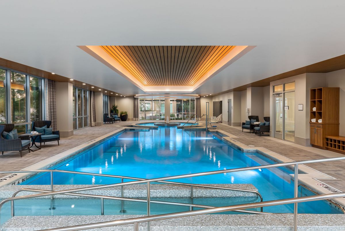 A luxurious indoor swimming pool with modern design and ambient lighting.