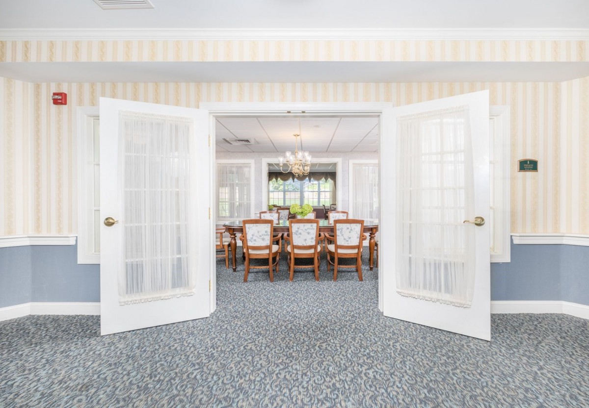 Spacious dining room with open double doors and elegant decor.