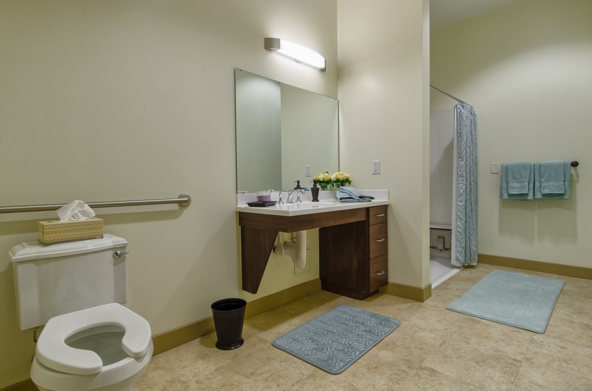 A modern bathroom with a shower, sink, and toilet.