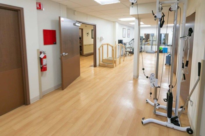 A well-equipped rehabilitation center with medical apparatus and an open space for therapy.
