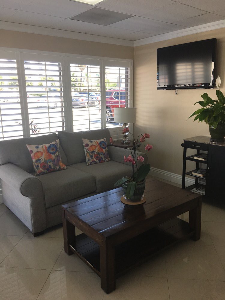 A cozy living room with a sofa, coffee table, and wall-mounted TV.