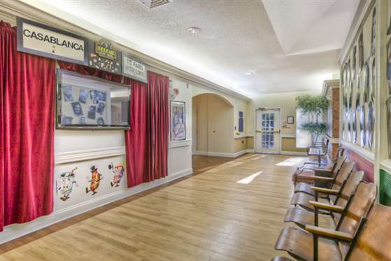A well-lit indoor waiting area with wooden flooring and decorative elements on the walls.