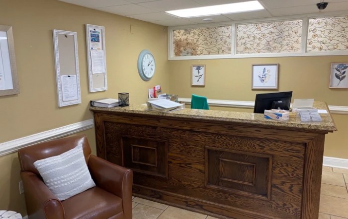 A cozy office reception area with a wooden desk and comfortable seating.