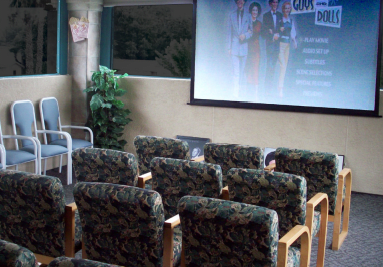 A conference room with rows of chairs facing a presentation screen.