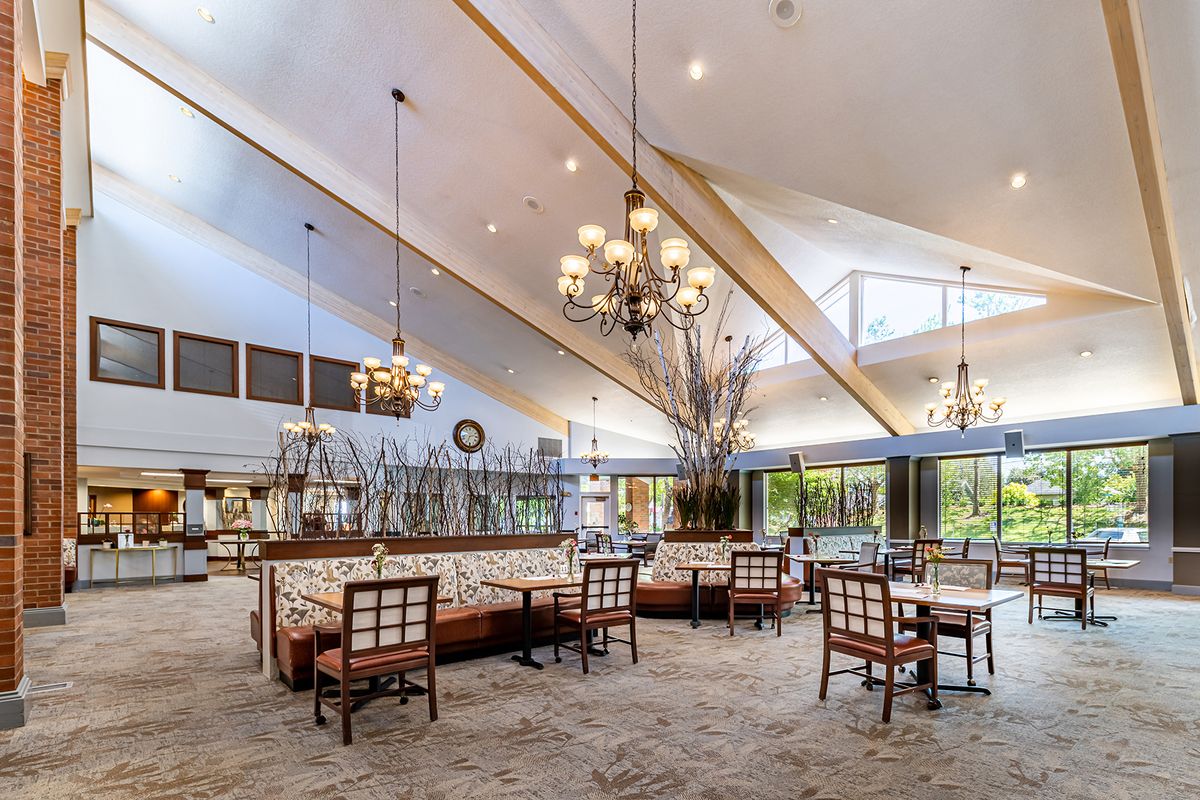 Spacious dining area with elegant chandeliers and large windows providing natural light.