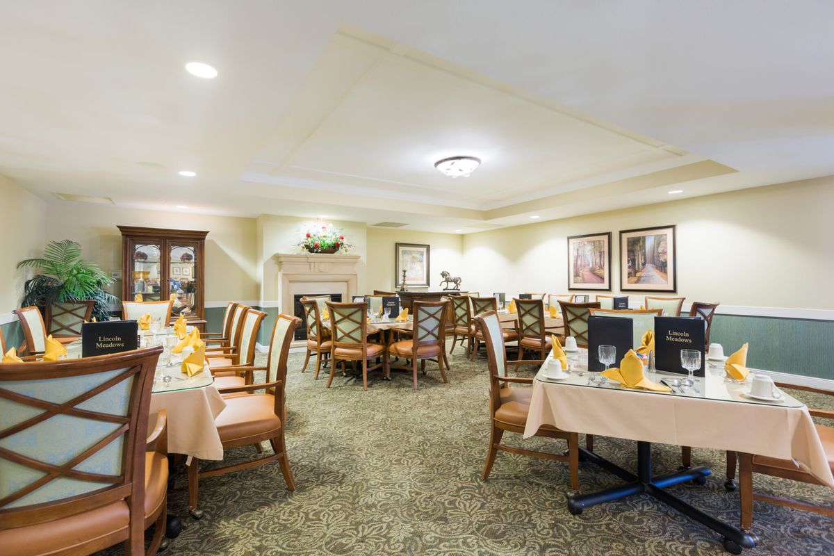 An elegant dining room interior with neatly arranged tables and chairs.