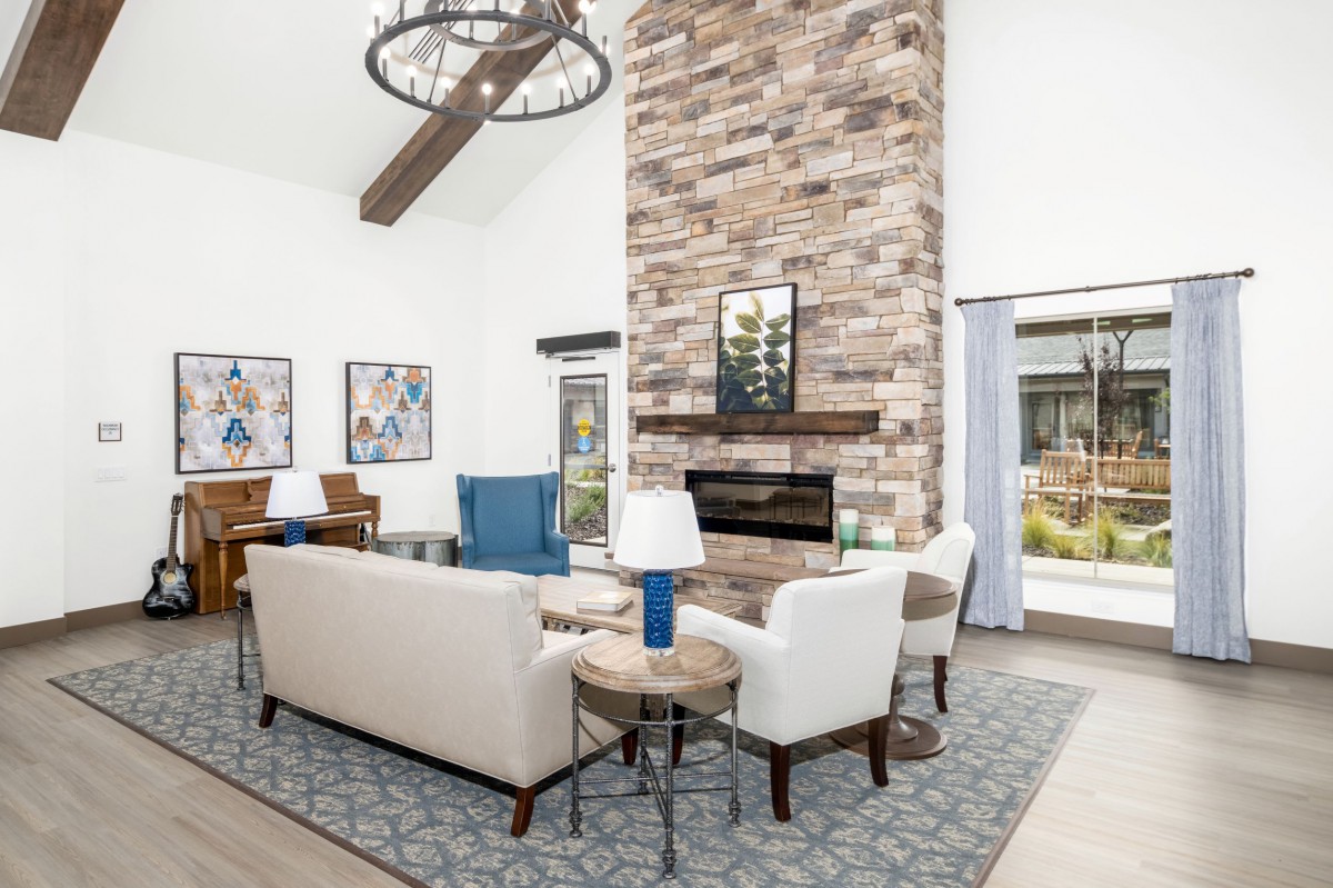 A spacious and elegantly designed living room featuring a stone fireplace, comfortable seating, and stylish decor.