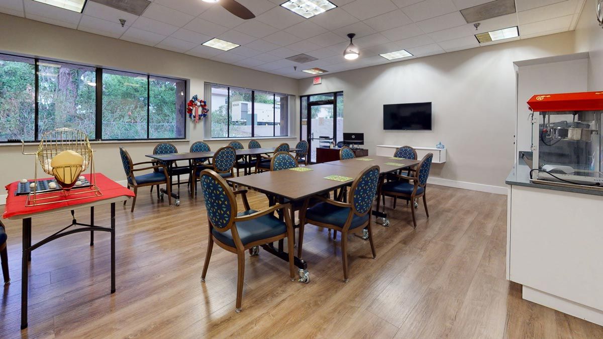 A well-lit meeting room with tables and chairs arranged for a group setting.