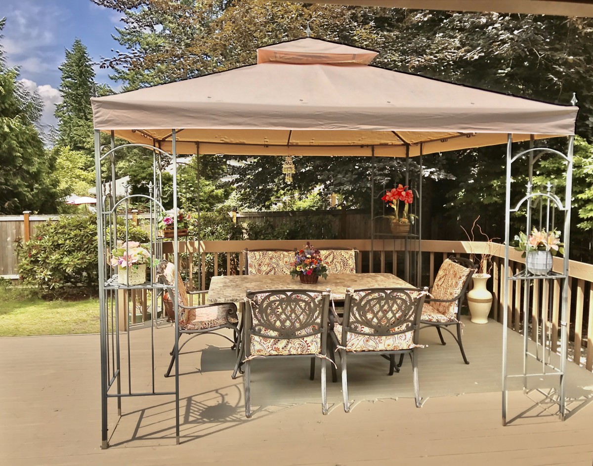 A cozy outdoor setup with a gazebo covering a patio table and chairs.
