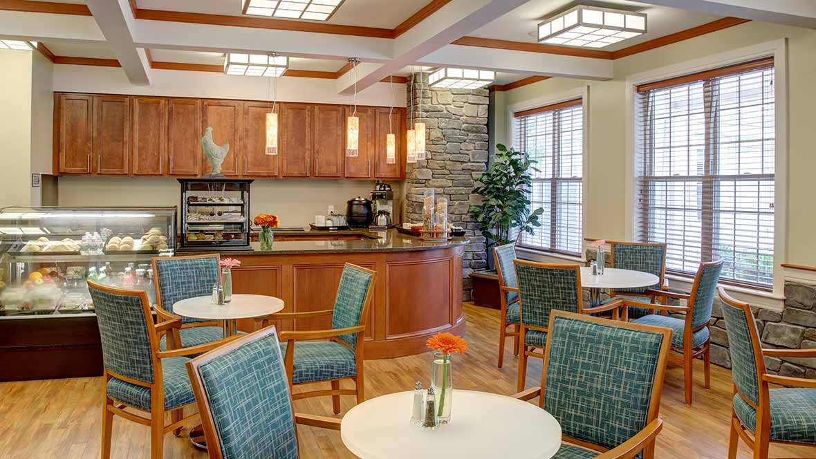 A cozy cafe interior with wooden decor, tables, and chairs.