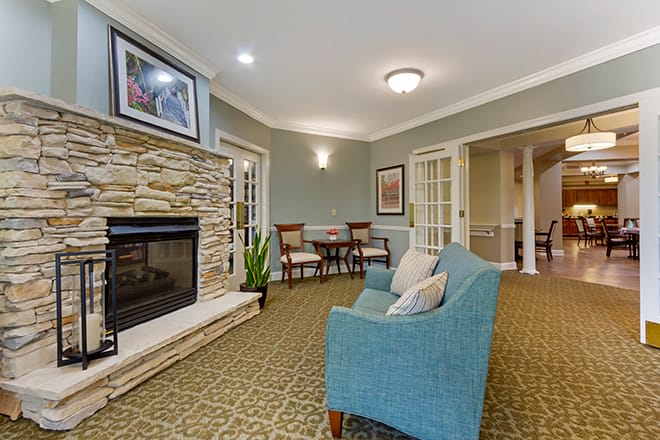 A cozy living room featuring a stone fireplace, comfortable armchair, and elegant decor.