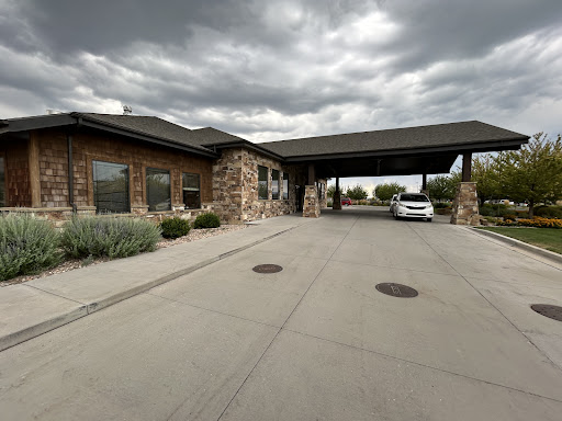 A welcoming entrance to a modern building under a partly cloudy sky.