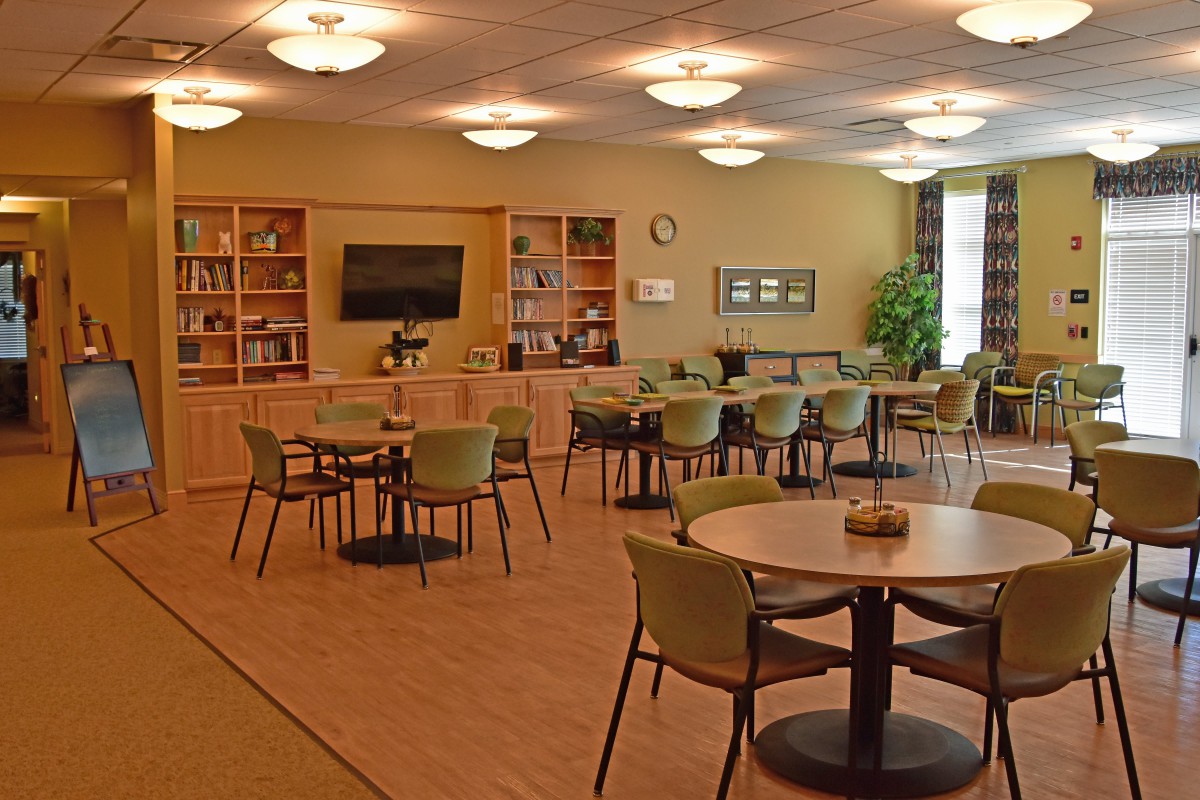 Spacious room with tables, chairs, and bookshelves.
