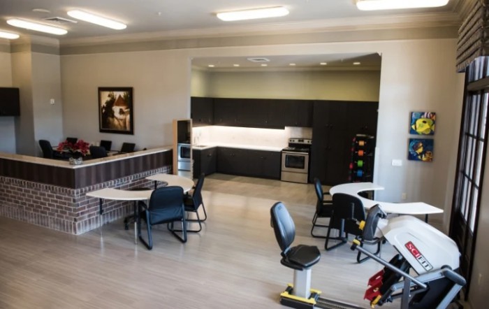 A modern office space featuring a kitchenette and seating area.