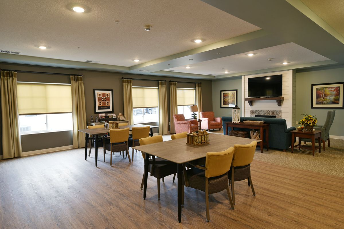A cozy dining area with tables and chairs, featuring a television and decorations.