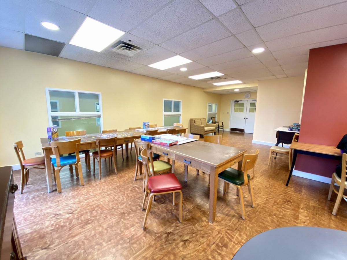An empty classroom with tables and chairs arranged neatly.