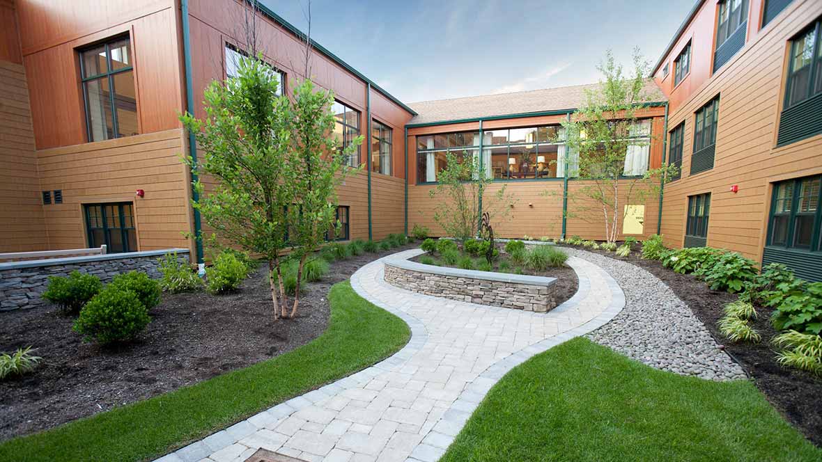 A landscaped courtyard with a winding pathway and surrounding greenery.