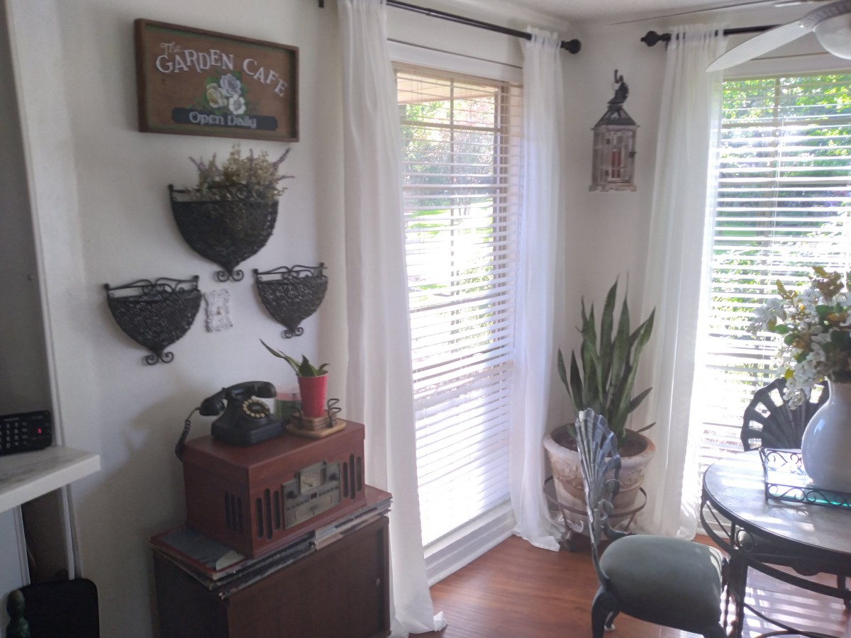 A cozy corner of a living room featuring natural light, house plants, and stylish decor.