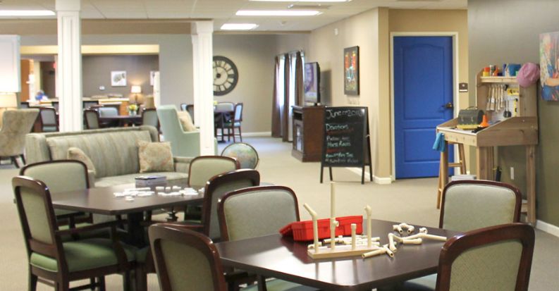 A cozy lounge area with tables, chairs, and recreational activities.
