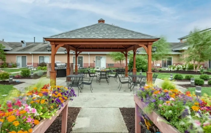 A charming gazebo with outdoor seating surrounded by vibrant flowerbeds.