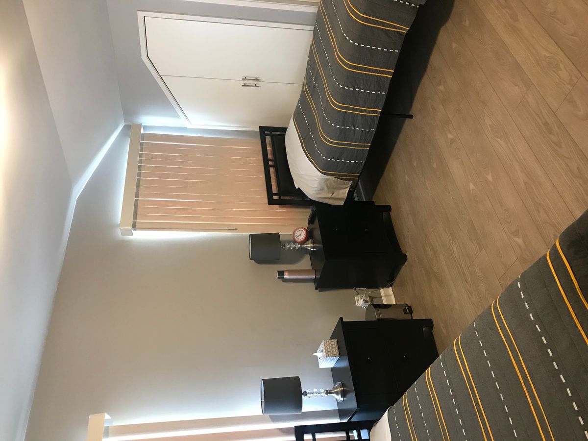 A modern bedroom with twin beds and matching nightstands.