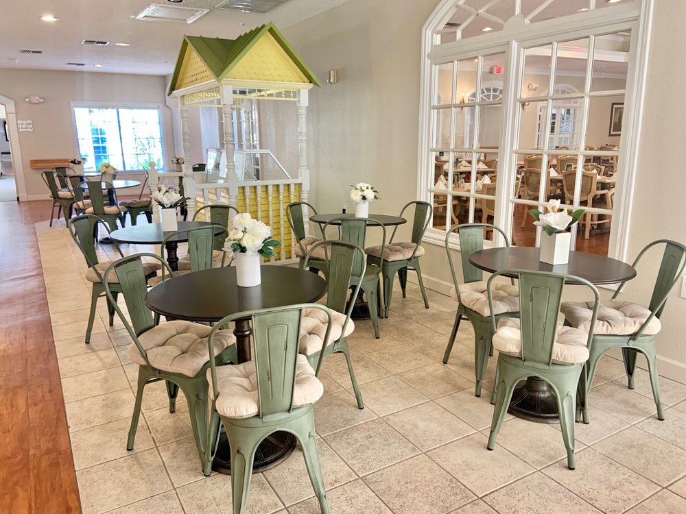 A cozy cafe interior with neatly arranged tables, chairs, and floral decor.