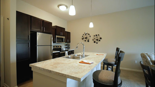 A modern kitchen featuring dark cabinetry and a spacious island with barstools.