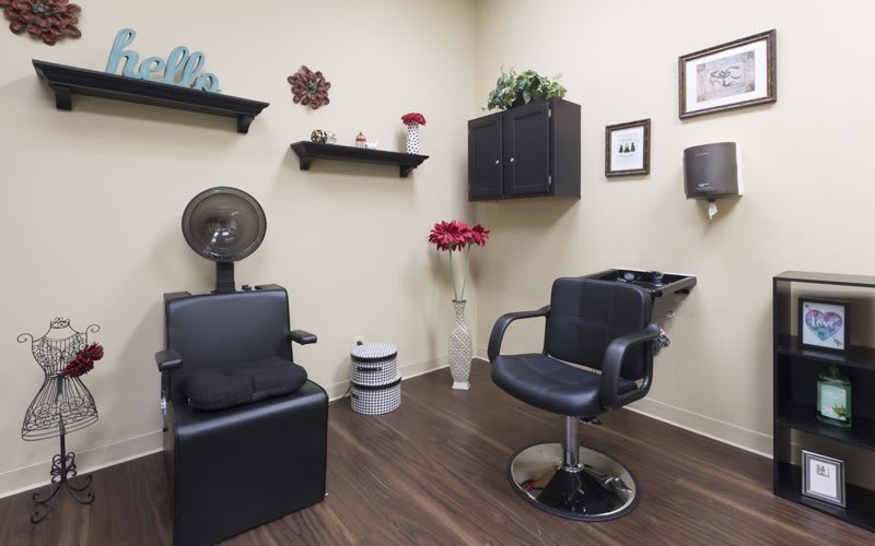A neatly organized hair salon with styling chairs and wall decorations.
