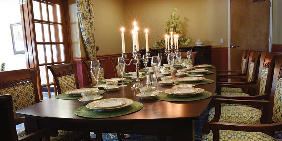 A beautifully set dining table with candles and elegant place settings.