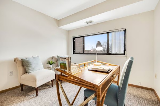 A bright and serene office space featuring a stylish desk and comfortable seating, perfect for productivity.
