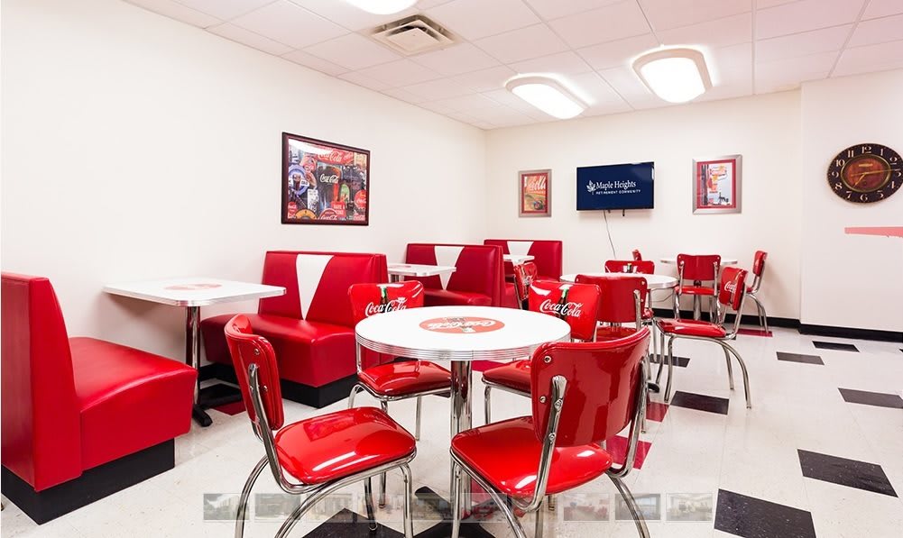 Retro-style diner interior with red chairs and booths.