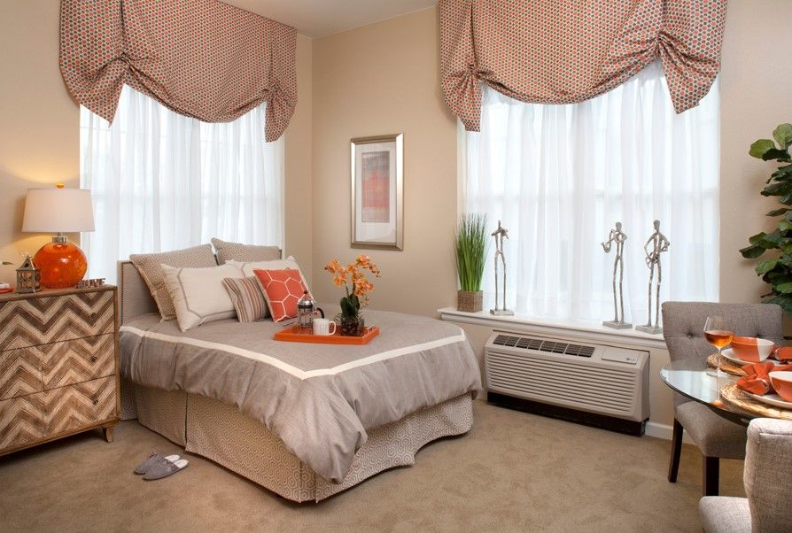 A cozy bedroom with elegant drapes and a well-made bed.