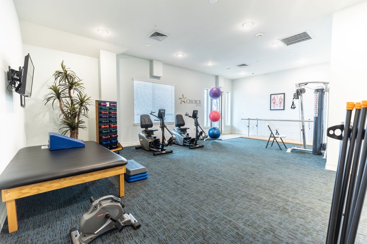 A spacious fitness room equipped with stationary bikes and therapy balls, designed for exercise and rehabilitation activities.