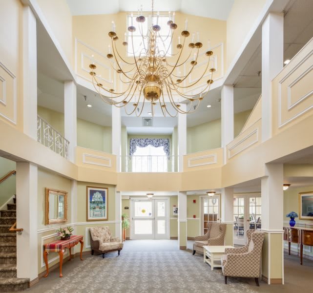 A spacious lobby area with a large chandelier and comfortable seating.