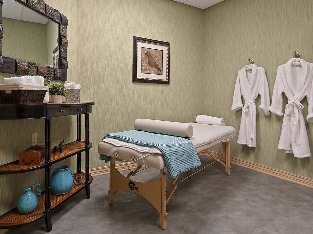 A serene massage room equipped with a treatment table and robe, perfect for relaxation and wellness.