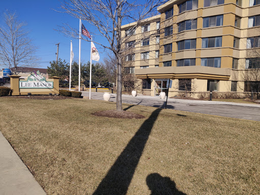 A view of a hotel building with flags and trees, set against a clear blue sky.