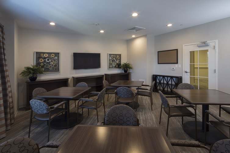 A modern conference room with tables and chairs set up for a meeting.