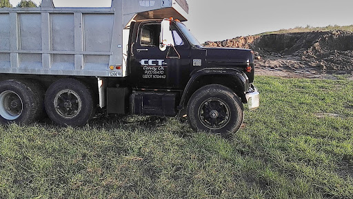 A black commercial truck parked on green grass in an outdoor setting.