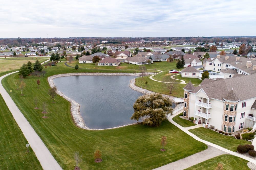 Aerial view of a residential neighborhood with a central lake and surrounding houses.