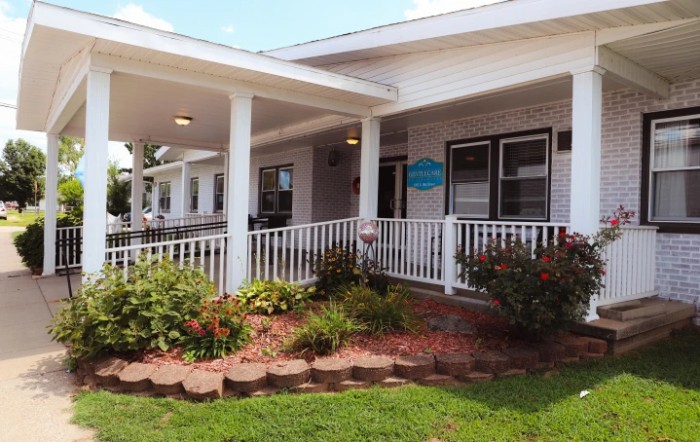 A single-story building with a white porch and well-maintained landscaping.