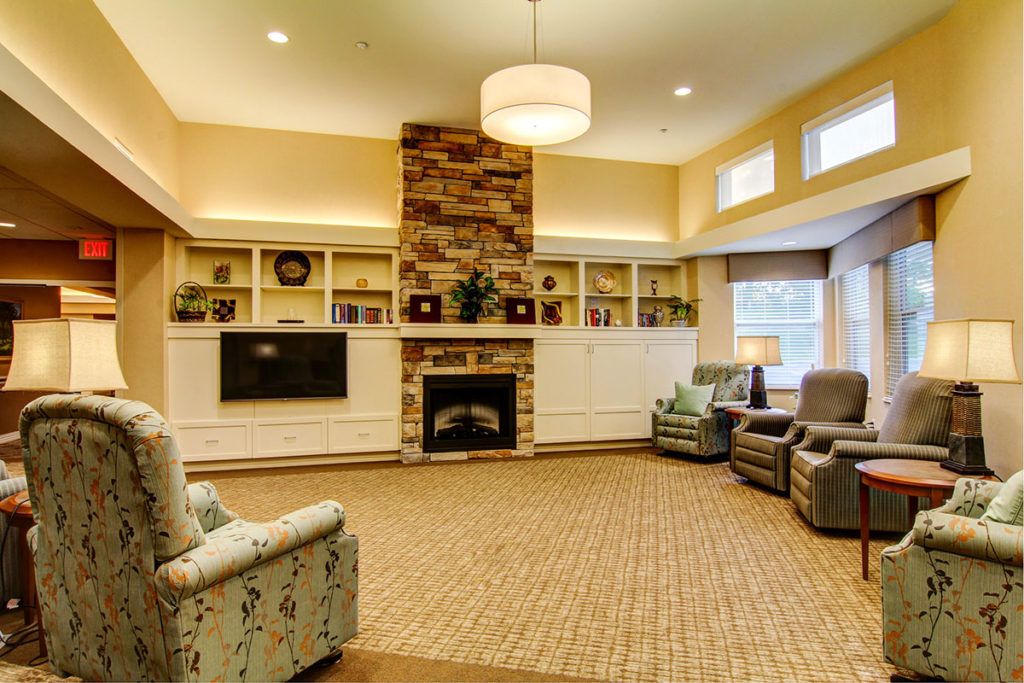 A cozy living room with a fireplace, comfortable seating, and warm lighting.