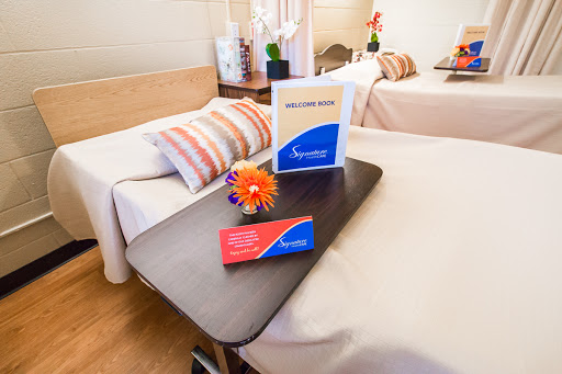 A well-appointed patient room in a medical facility, featuring comfortable beds and decorative elements.